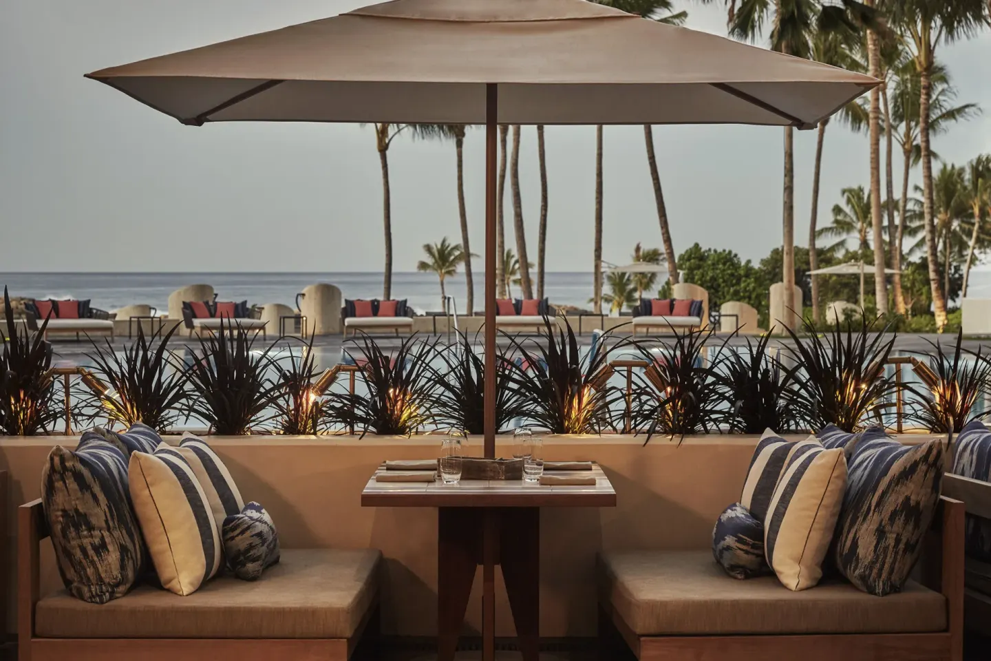 Poolside dining banquette under an umbrella at Four Seasons Resort Oahu at Ko Olina.