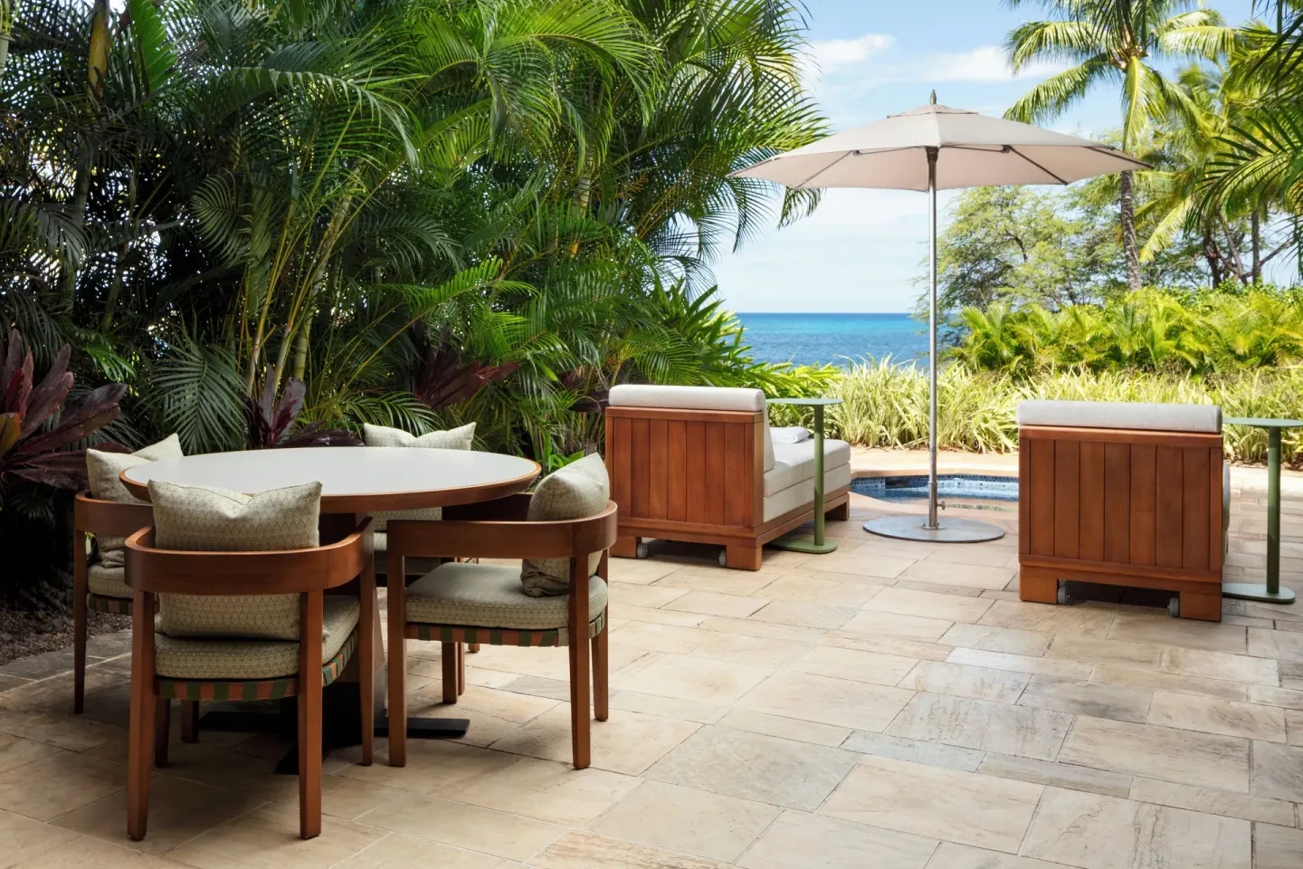 Club Room terrace with dining table, umbrella, spa tub and ocean view at Four Seasons Resort Oahu at Ko Olina.