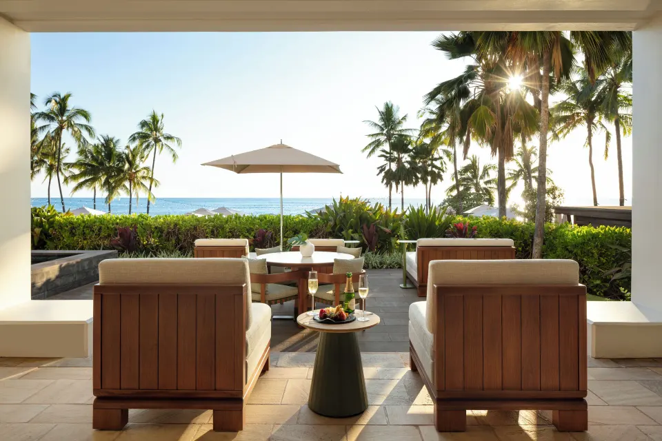 Pacific Suite terrace at Four Seasons Resort Oahu at Ko Olina with outdoor seating and ocean beyond palms.