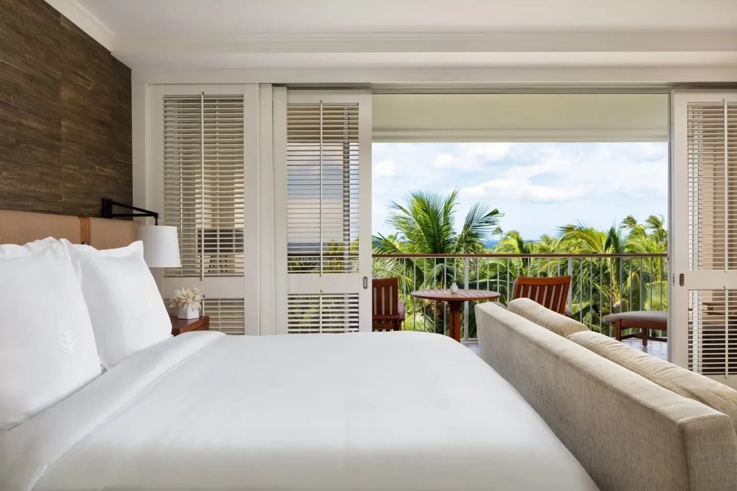 Partial Ocean Room king bed and balcony at Four Seasons Resort Oahu at Ko Olina.