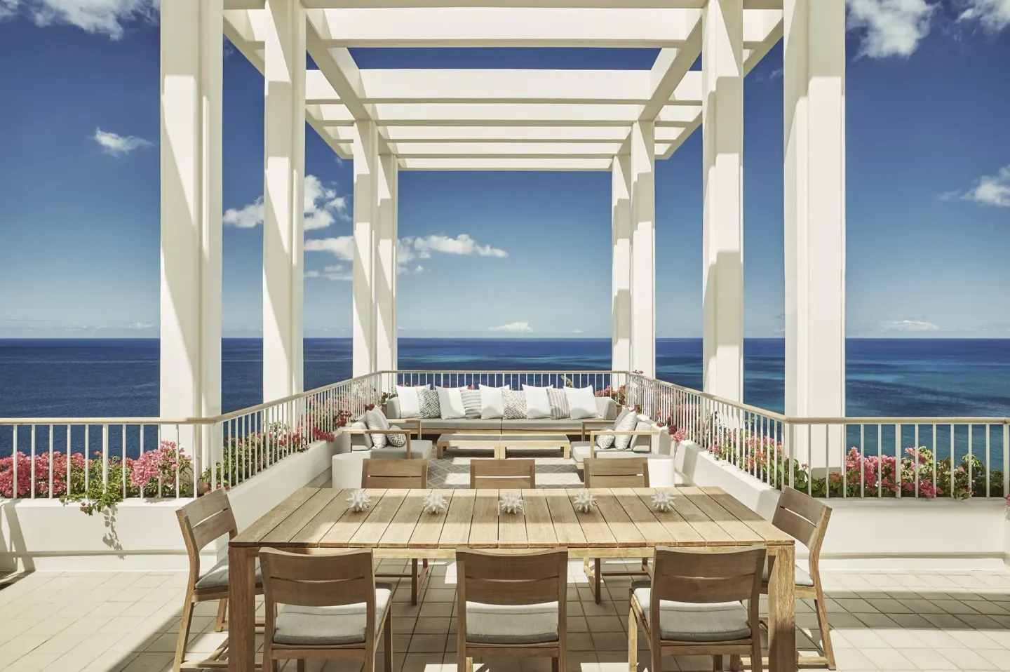 Penthouse Suite terrace dining table and lounge at Four Seasons Resort Oahu at Ko Olina.