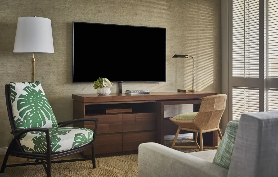 Resort Room living area with TV, desk, chair and shutters at Four Seasons Resort Oahu at Ko Olina.