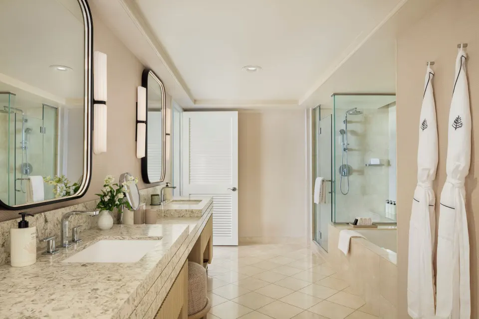 Sunset Suite bathroom with double vanity and glass shower at Four Seasons Resort Oahu at Ko Olina.