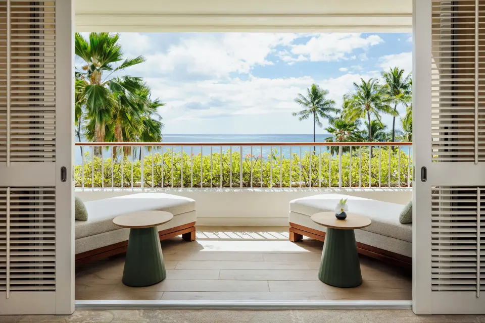Sunset Suite lanai daybeds overlooking palms and ocean at Four Seasons Resort Oahu at Ko Olina.