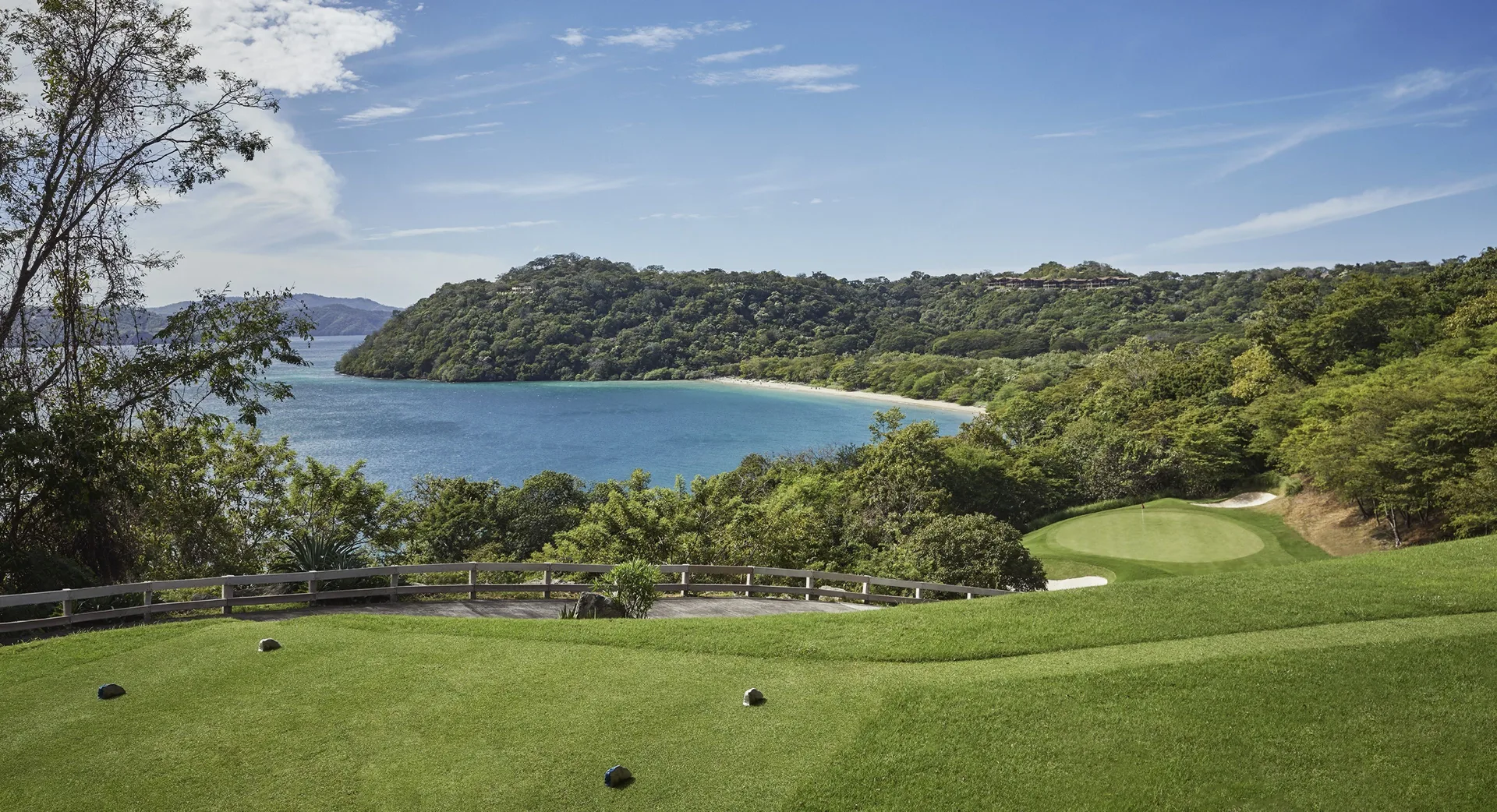 Golf green overlooking a blue bay at Four Seasons Resort Peninsula Papagayo, Costa Rica.