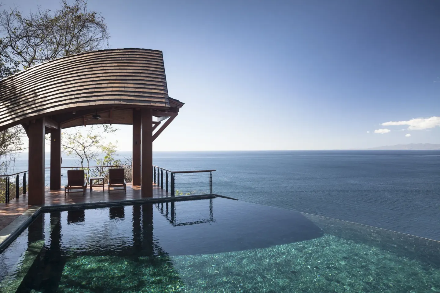Infinity pool and shaded overlook above the ocean at Four Seasons Resort Peninsula Papagayo, Costa Rica.