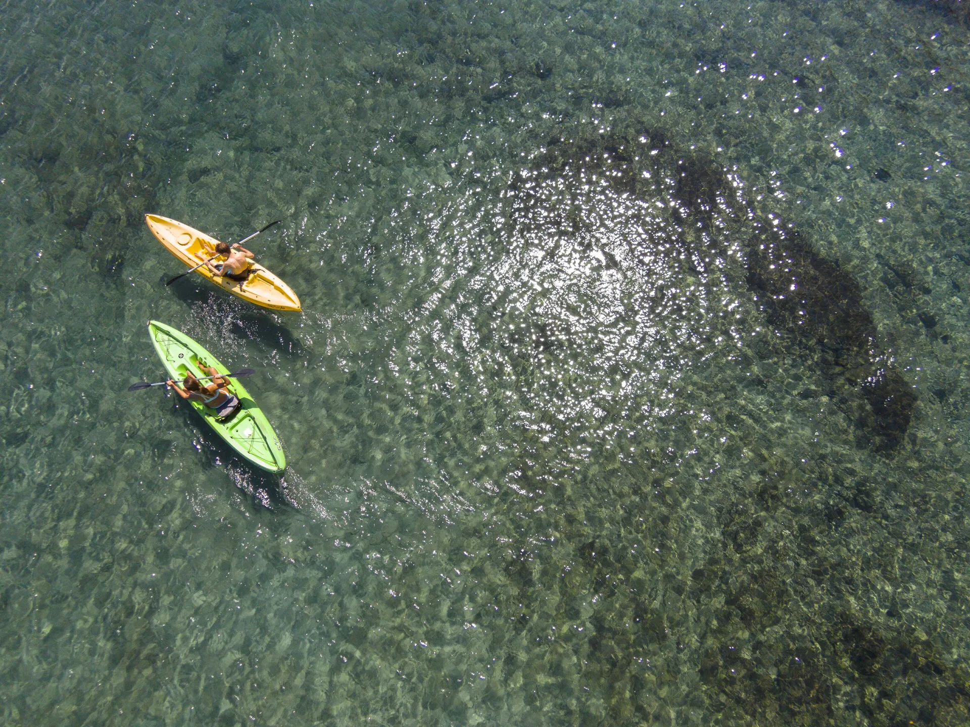 Two kayaks paddle over clear water at Four Seasons Resort Peninsula Papagayo, Costa Rica.