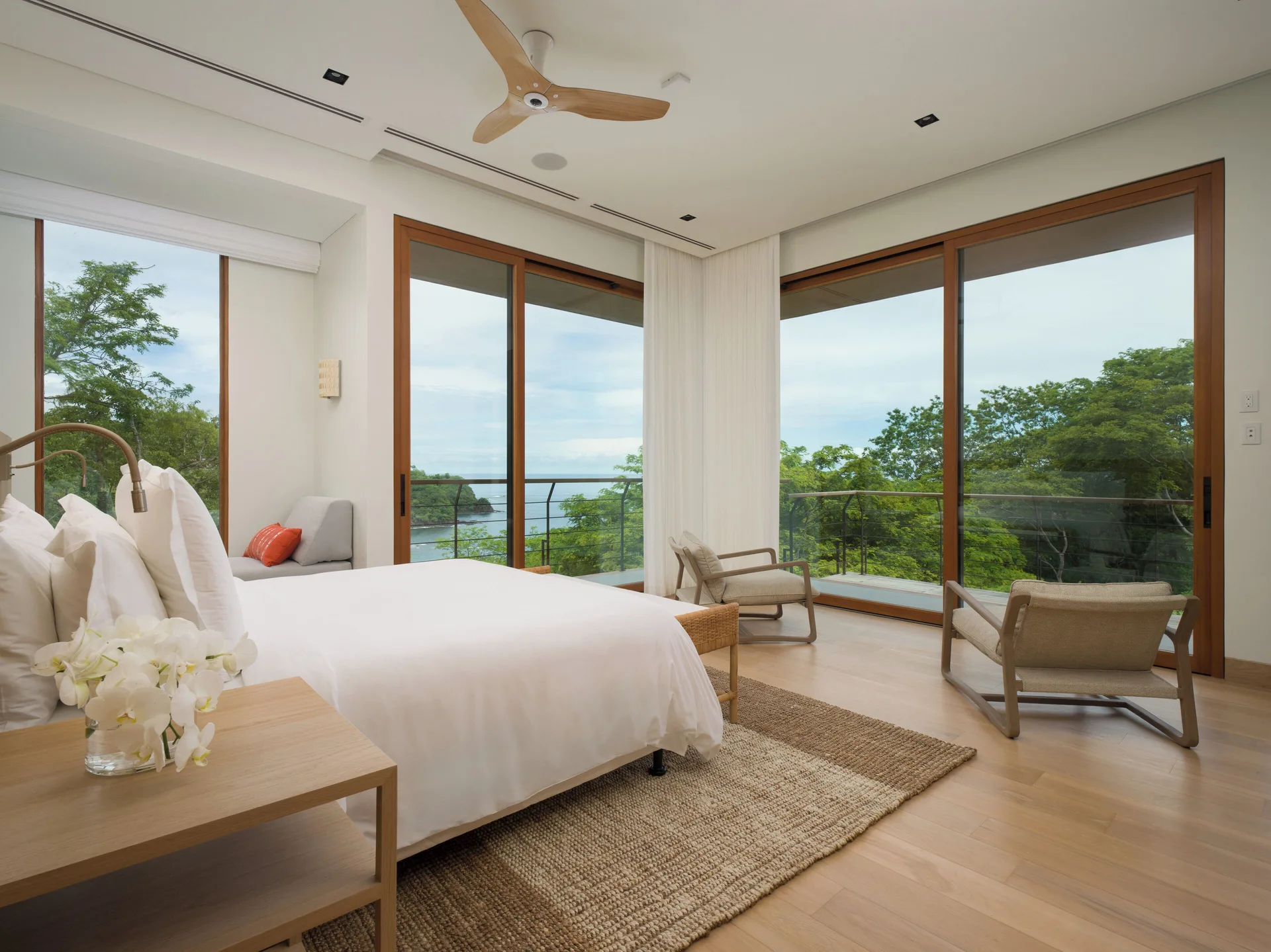 King bedroom with floor-to-ceiling windows at Four Seasons Resort Peninsula Papagayo, Costa Rica.