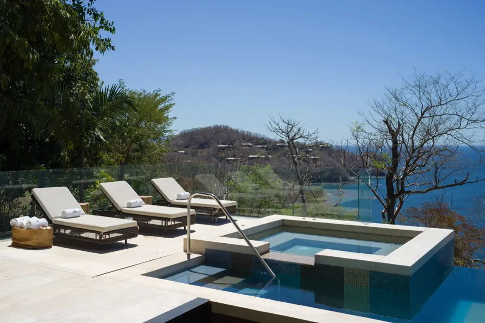 Pool terrace with loungers and ocean views at Four Seasons Resort Peninsula Papagayo, Costa Rica.