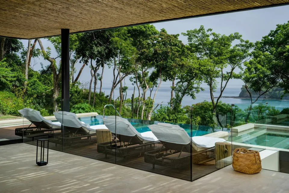 Pool terrace with loungers and ocean view at Four Seasons Resort Peninsula Papagayo, Costa Rica.