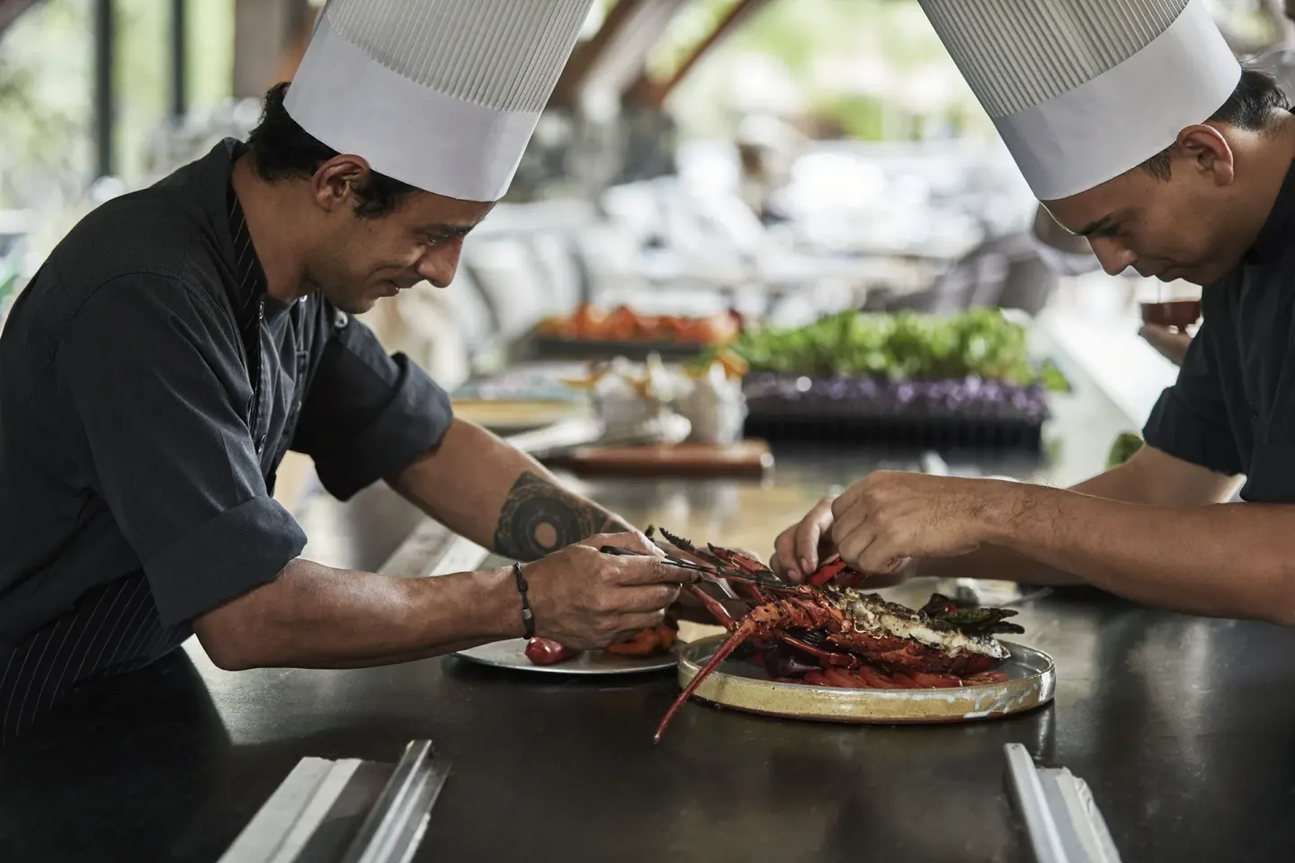 Chefs prepare lobster in an open kitchen at Four Seasons Resort Peninsula Papagayo, Costa Rica.
