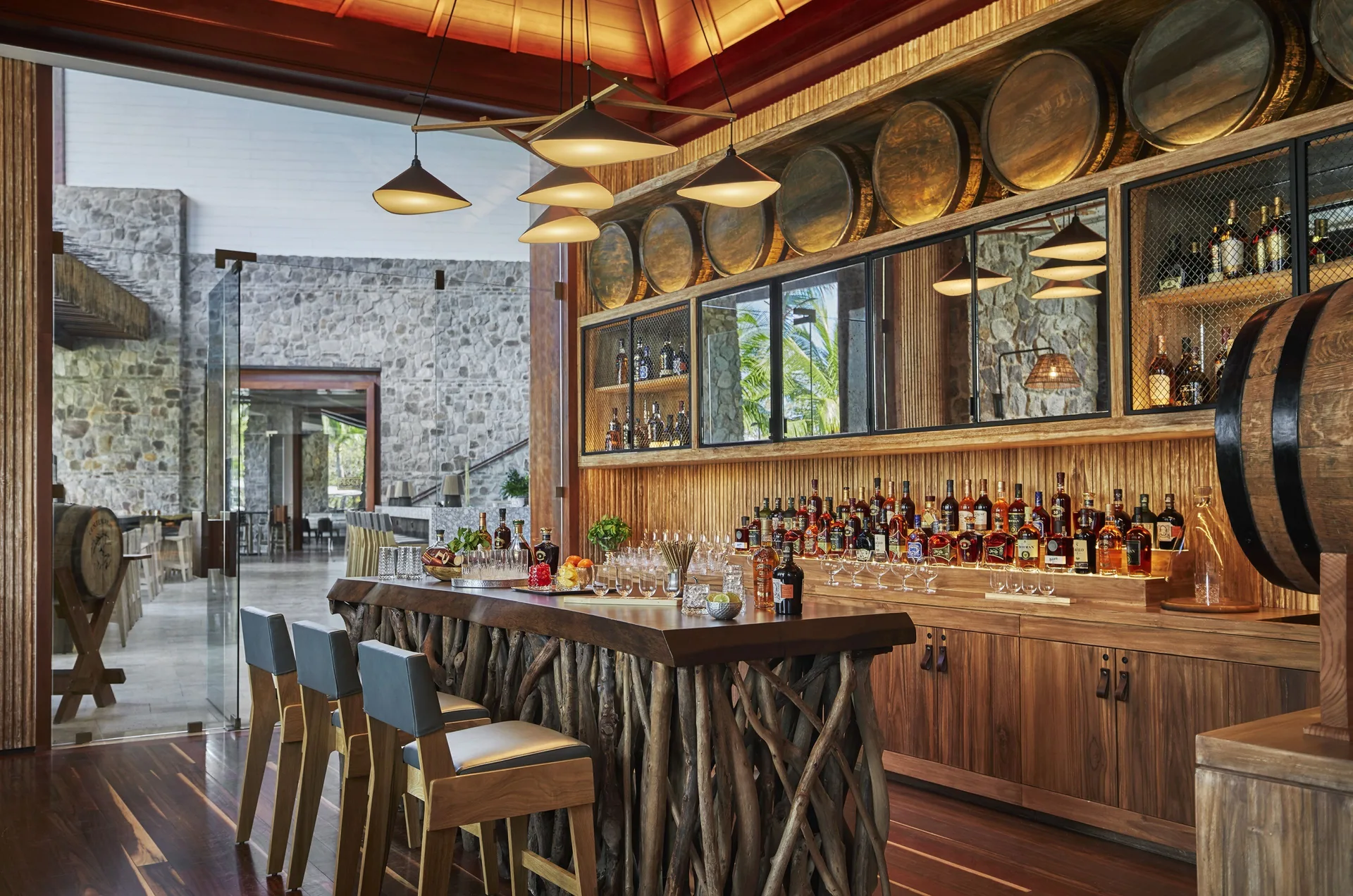 Rum bar with bottles, barrels and wood details at Four Seasons Resort Peninsula Papagayo, Costa Rica.