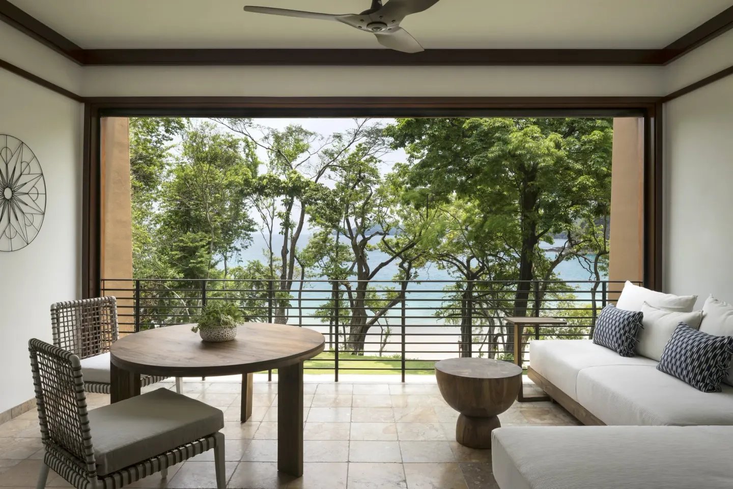 Furnished terrace with trees and water view at Four Seasons Resort Peninsula Papagayo, Costa Rica.
