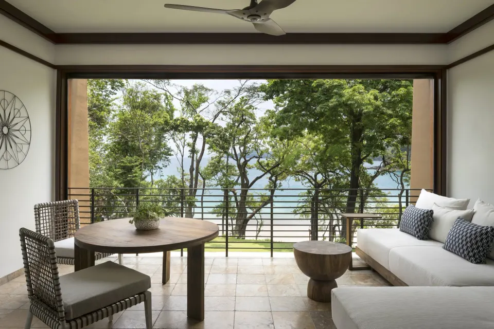 Furnished terrace with trees and water view at Four Seasons Resort Peninsula Papagayo, Costa Rica.