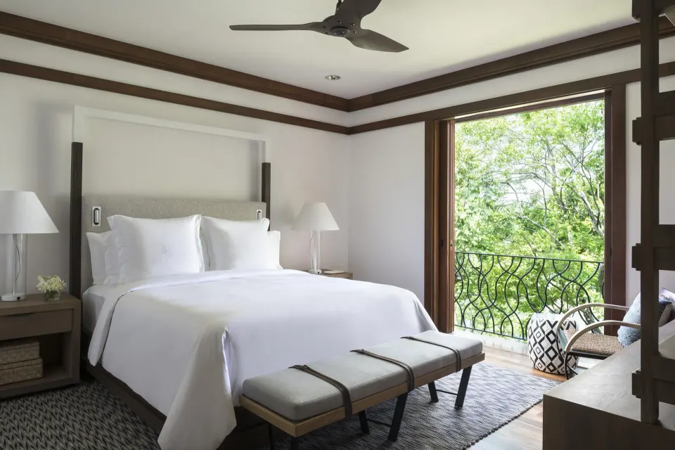 Canopy one-bedroom suite bed and balcony greenery at Four Seasons Resort Peninsula Papagayo, Costa Rica.