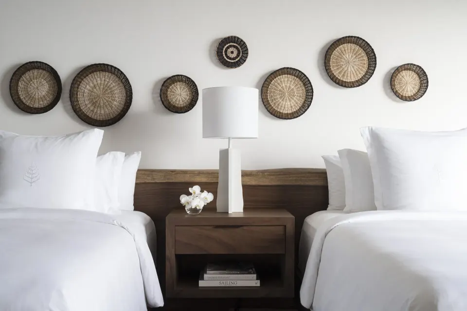 Two villa beds with woven wall art at Four Seasons Resort Peninsula Papagayo, Costa Rica.