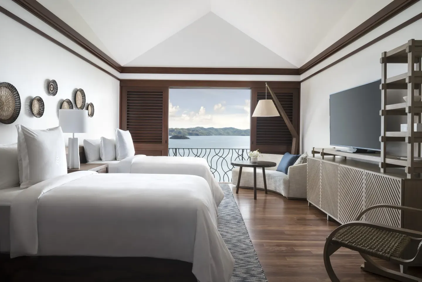 Two-bed villa bedroom opening to a private balcony at Four Seasons Resort Peninsula Papagayo, Costa Rica.