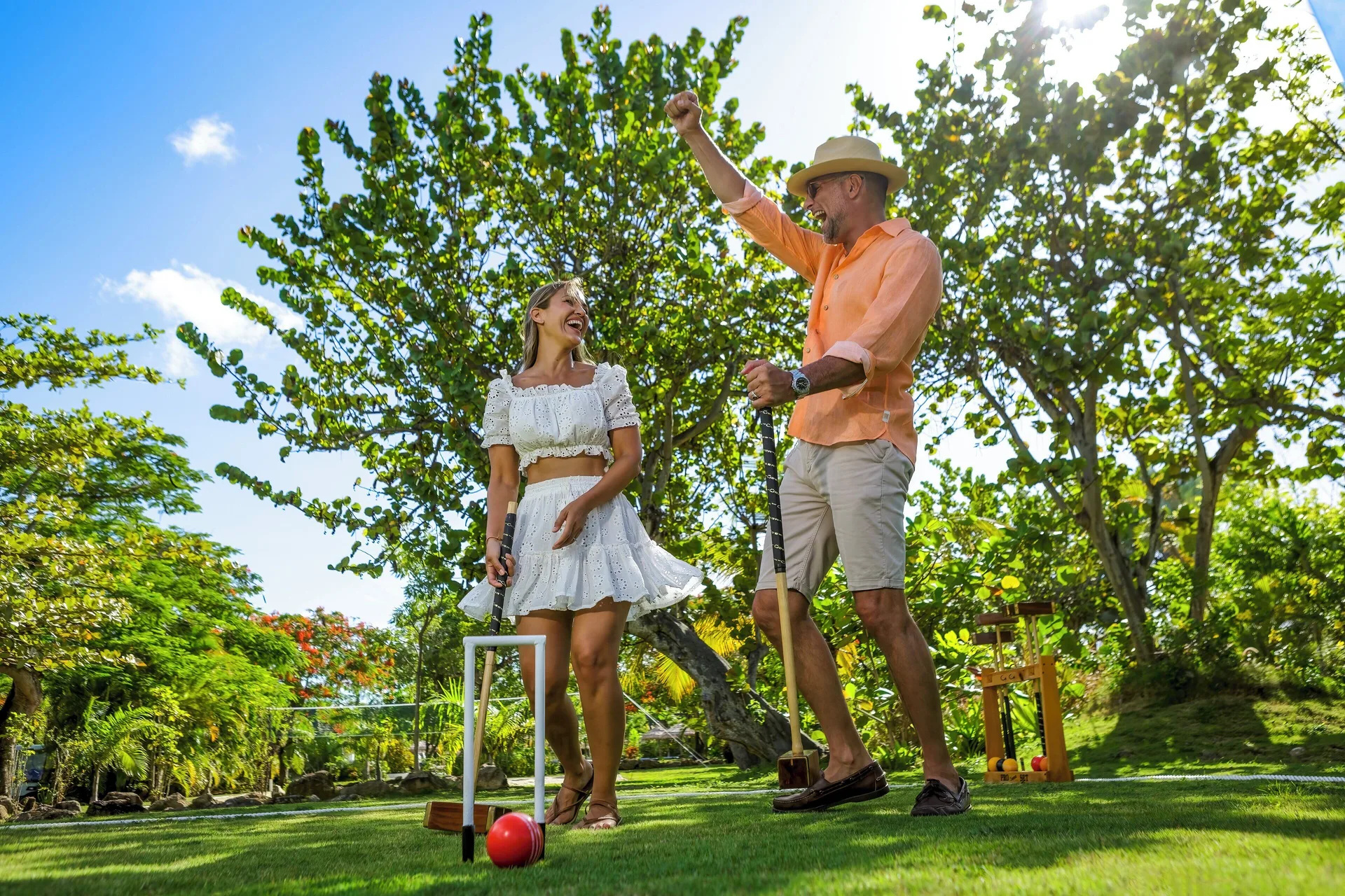 Guests play croquet on a grassy lawn at Galley Bay Resort & Spa.