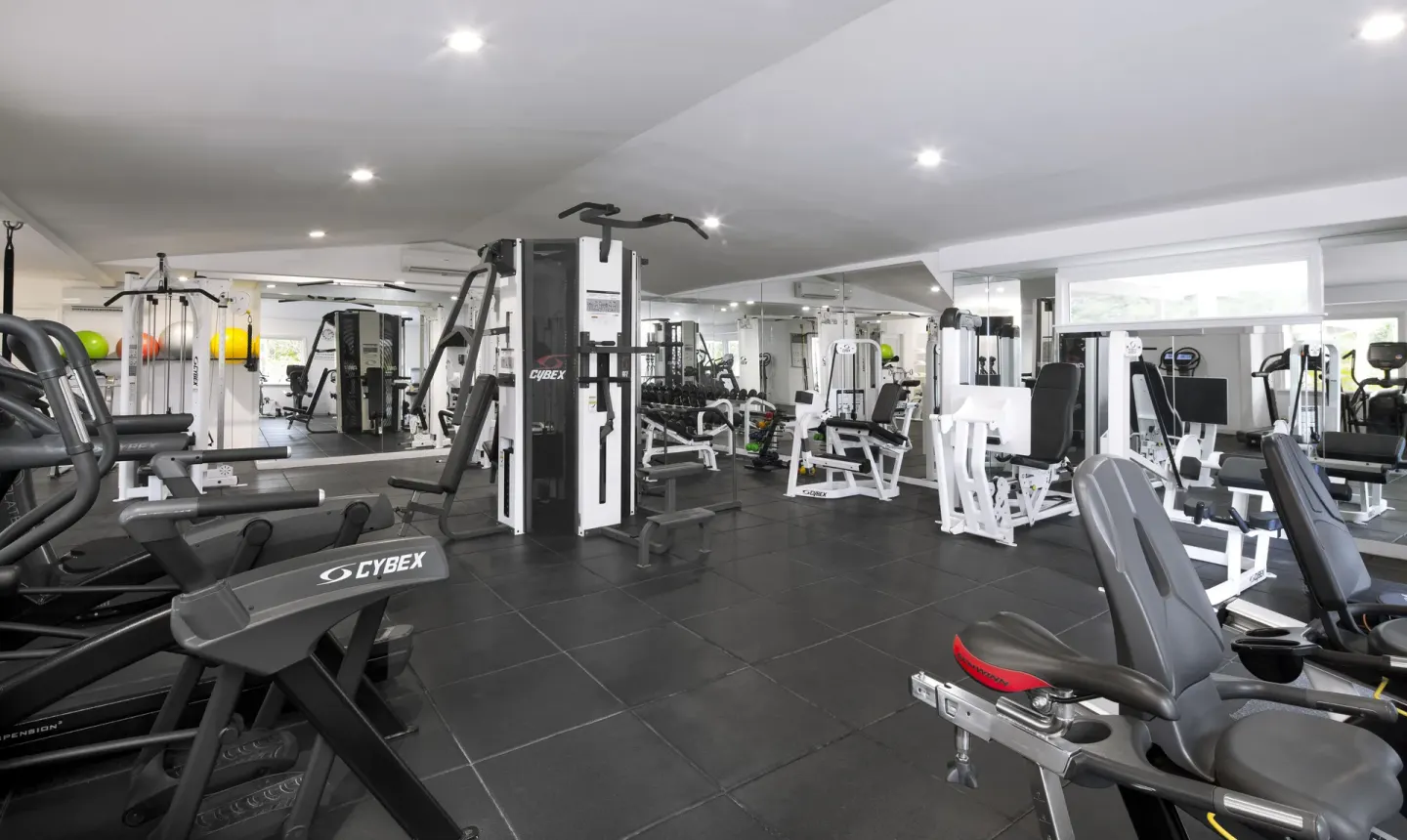 Fitness room with cardio machines, weights, and resistance equipment at Galley Bay Resort & Spa.