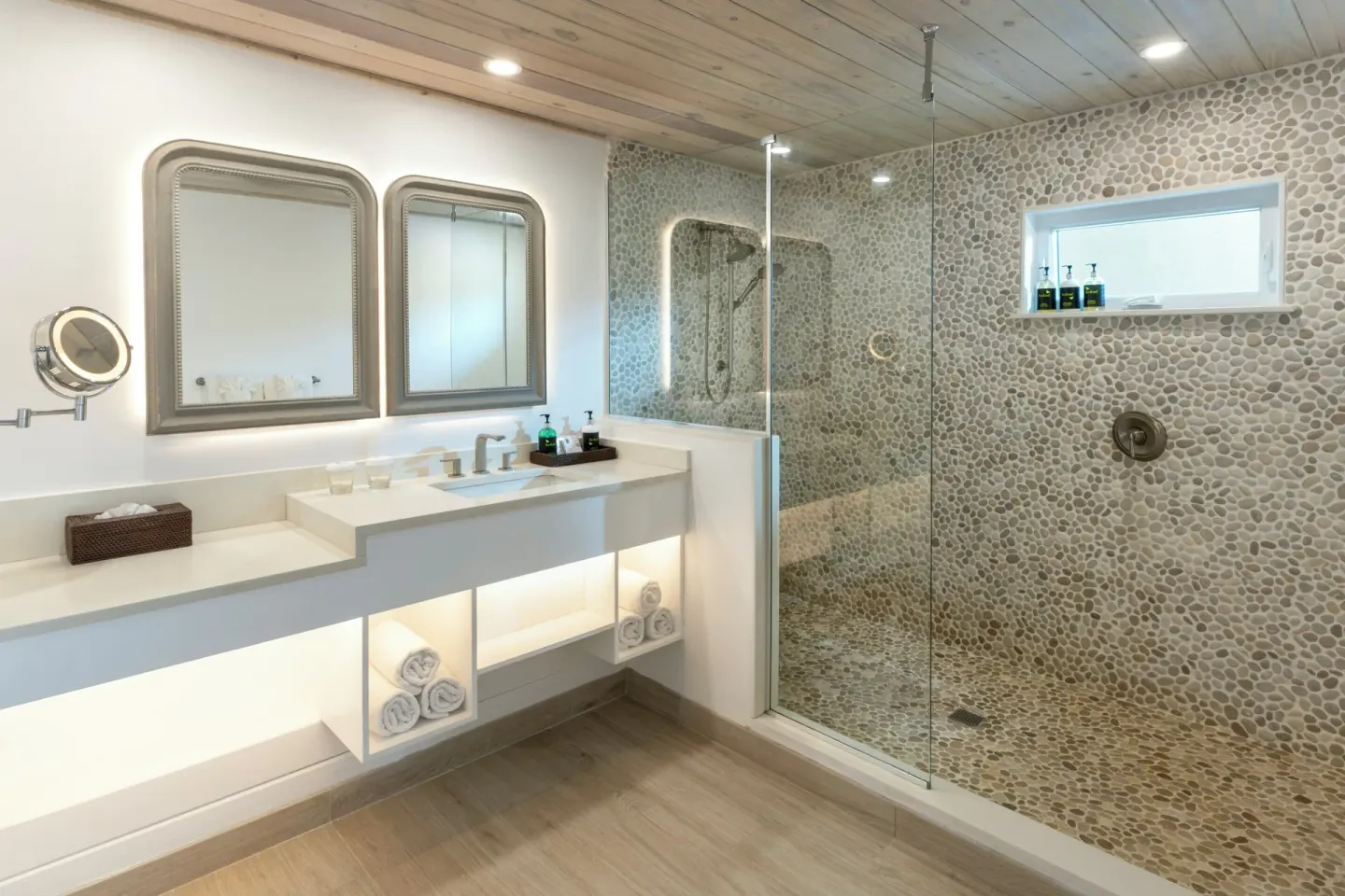 Guest bathroom with glass shower, double mirrors and vanity at Galley Bay Resort & Spa.