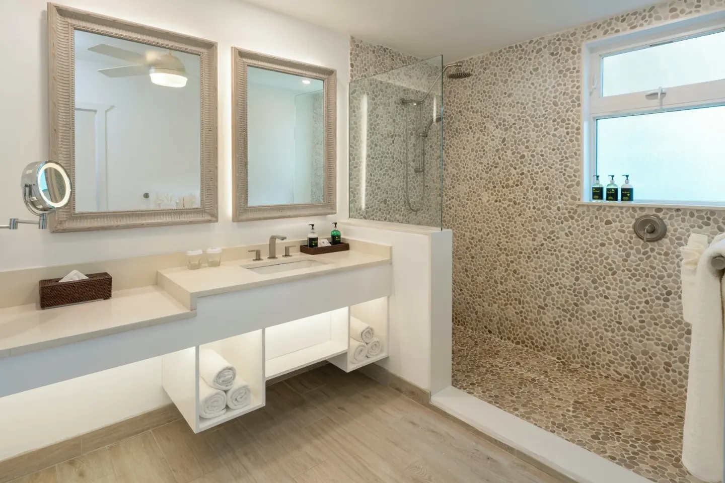 Guest bathroom with open shower and twin mirrors at Galley Bay Resort & Spa.