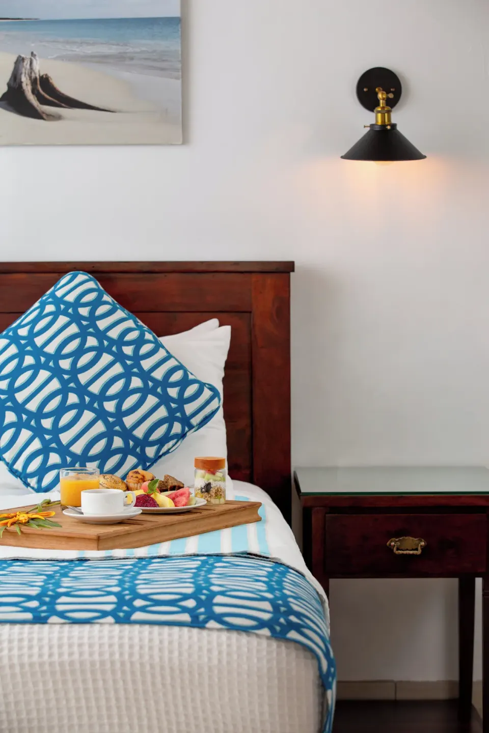 Bed detail with blue patterned pillows and breakfast tray at Galley Bay Resort & Spa.