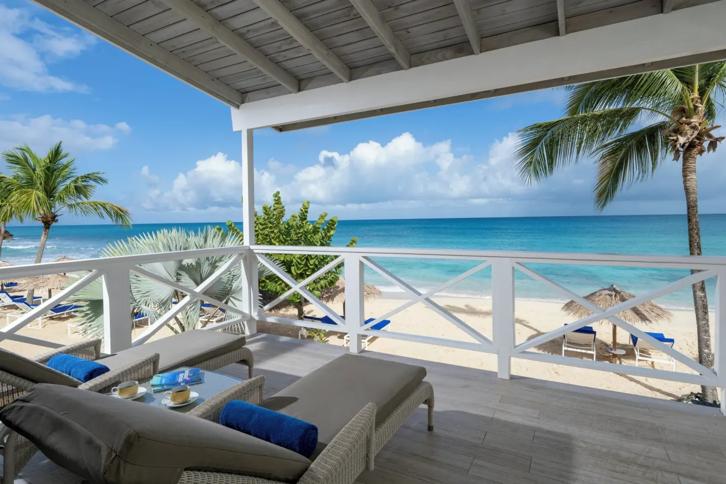Covered oceanfront terrace with loungers facing the beach at Galley Bay Resort & Spa.