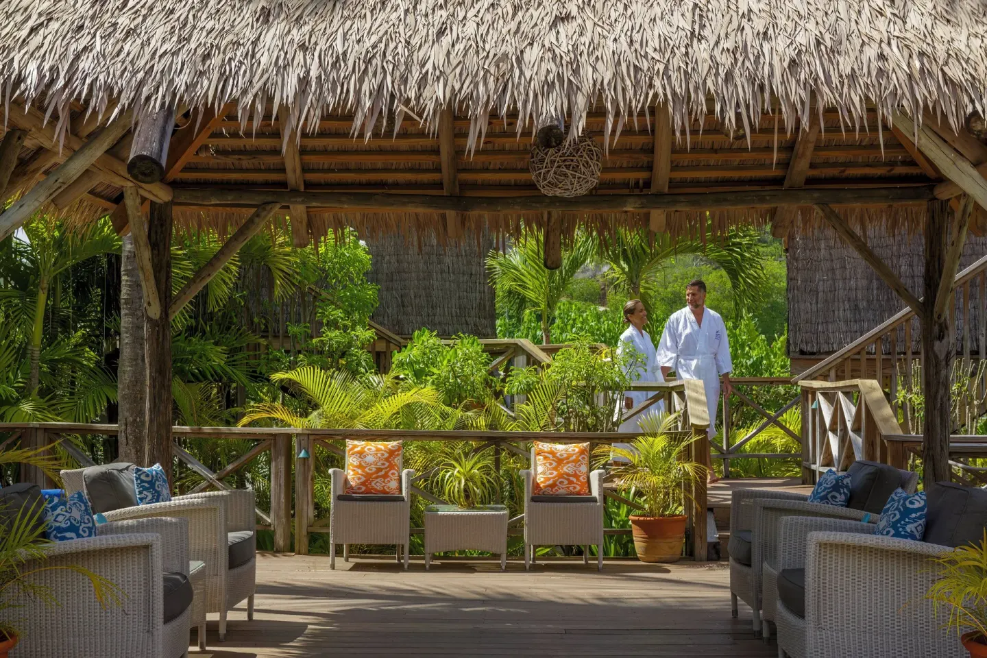 Thatched lounge deck with wicker seating in the gardens at Galley Bay Resort & Spa.
