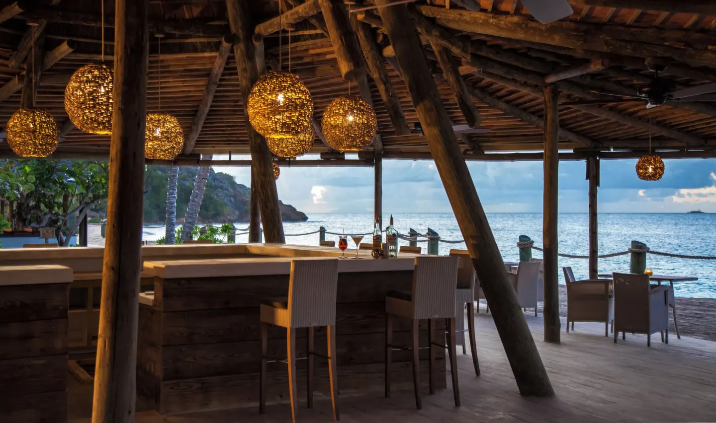 Beachfront open-air bar and dining deck at Galley Bay Resort & Spa.