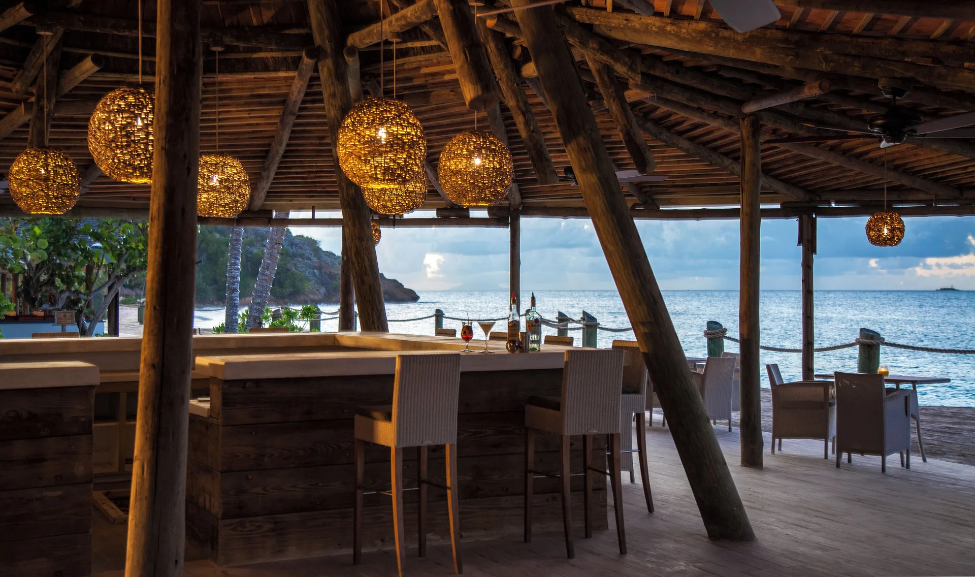 Beachfront open-air bar and dining deck at Galley Bay Resort & Spa.