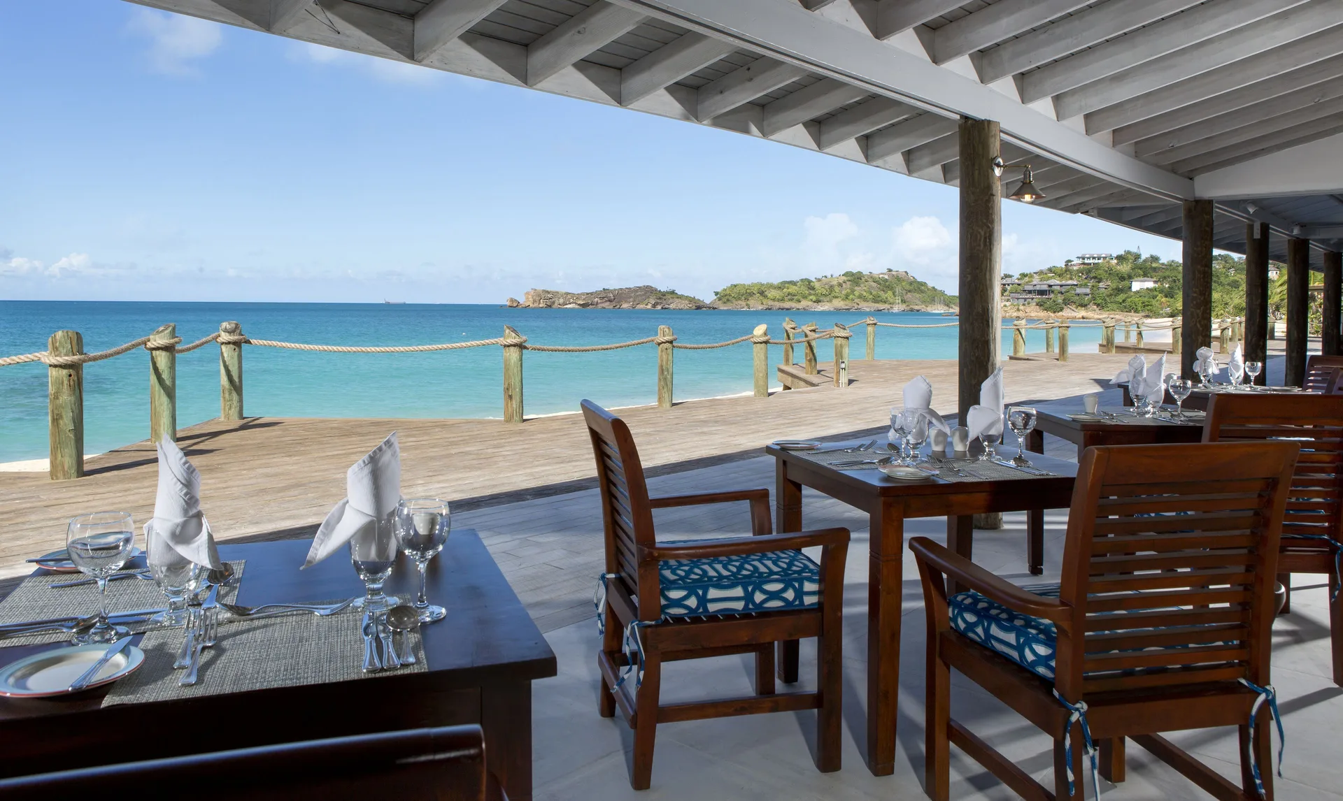 Oceanfront dining tables overlook the turquoise water at Galley Bay Resort & Spa.