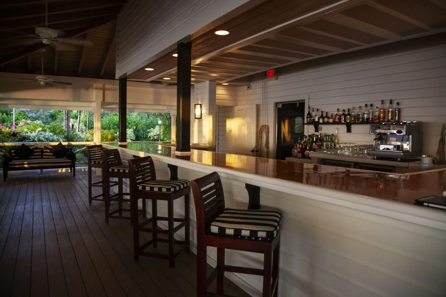 Open-air bar counter with striped stools at Galley Bay Resort & Spa.