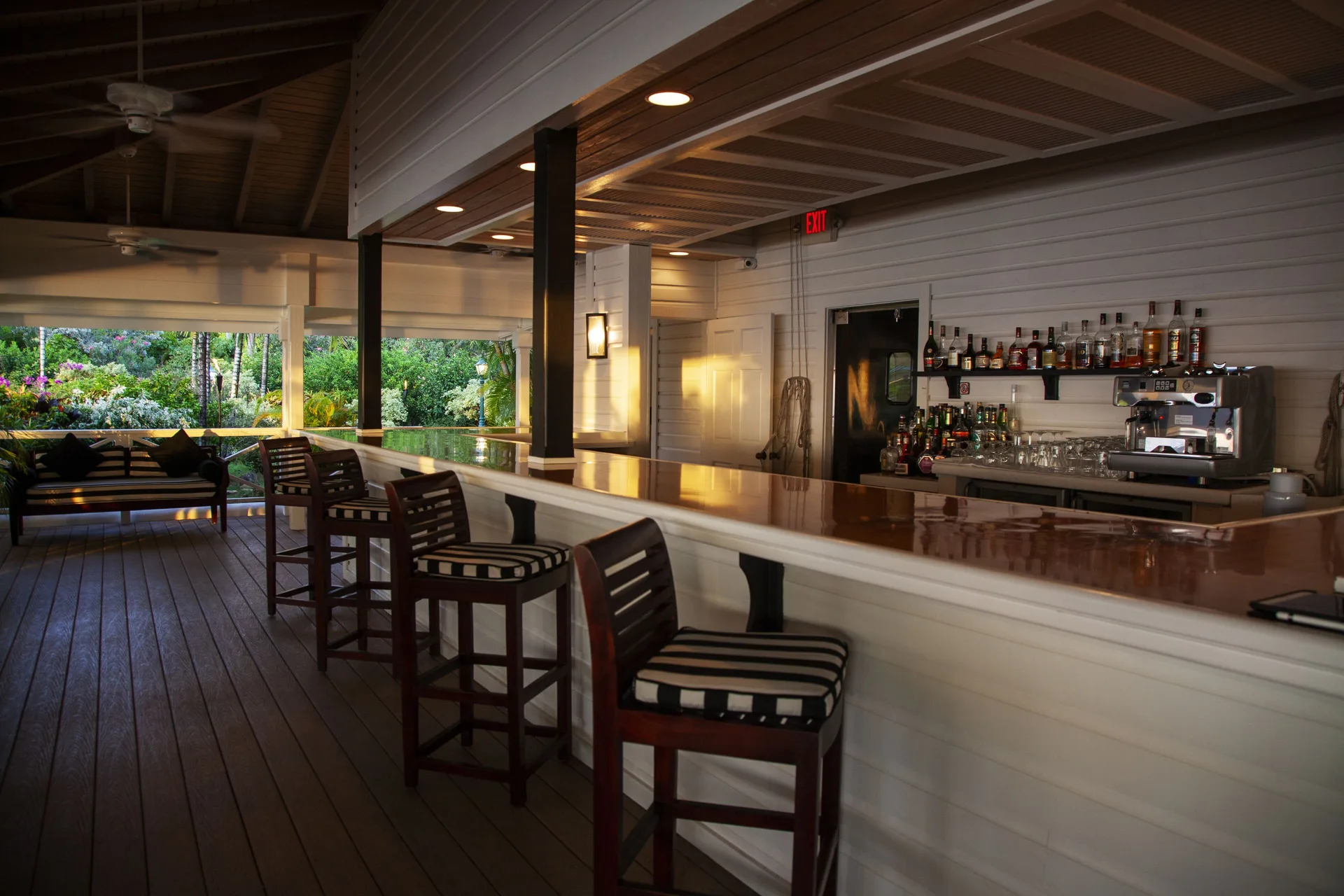 Open-air bar counter with striped stools at Galley Bay Resort & Spa.
