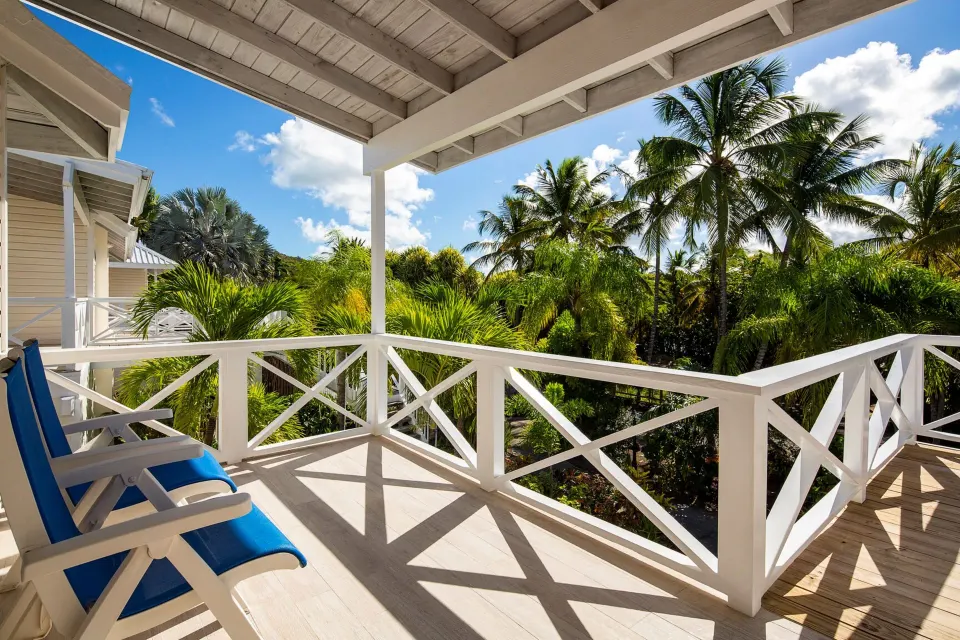 Deluxe Beachfront balcony with blue lounge chairs at Galley Bay Resort & Spa.