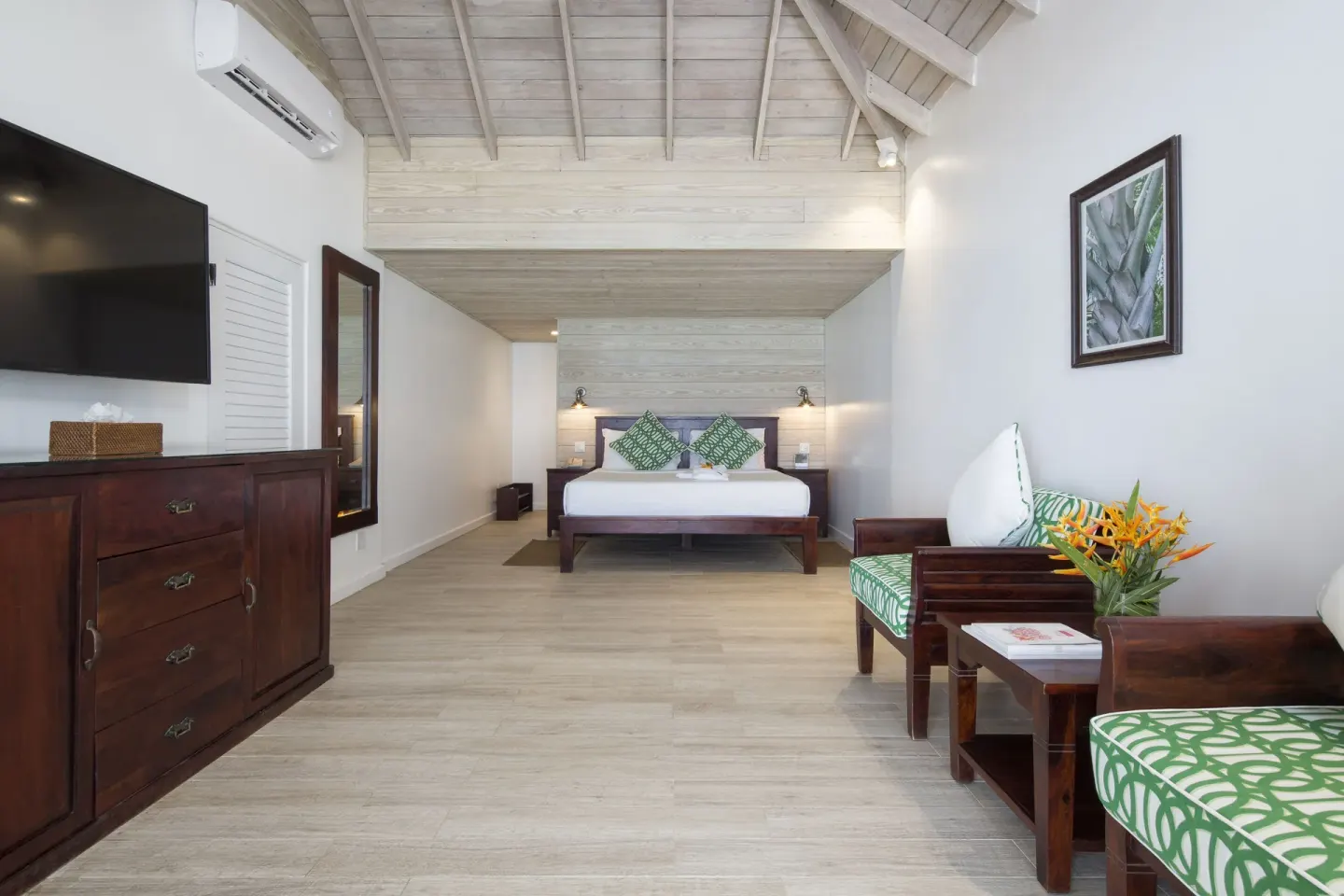 Superior Deluxe Beachfront king bed with sitting chairs at Galley Bay Resort & Spa.
