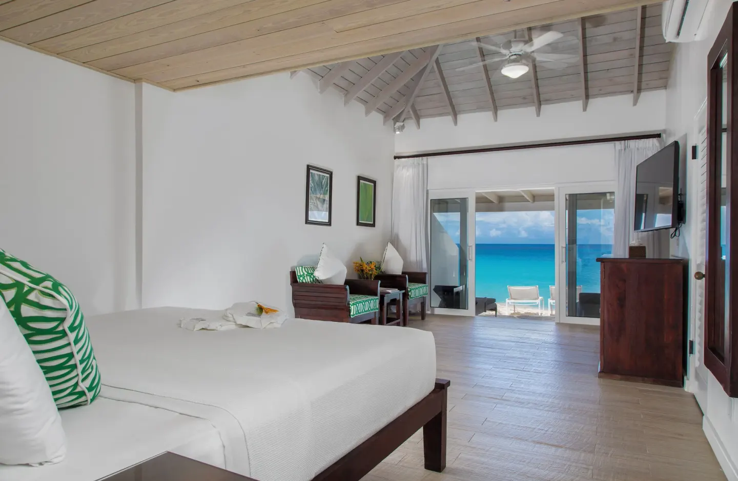 King bed and open doors to the beachfront terrace at Galley Bay Resort & Spa.