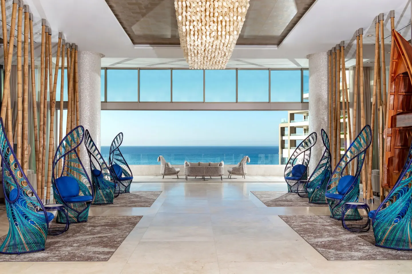 Lobby lounge with peacock-style chairs and ocean backdrop at Garza Blanca Los Cabos.