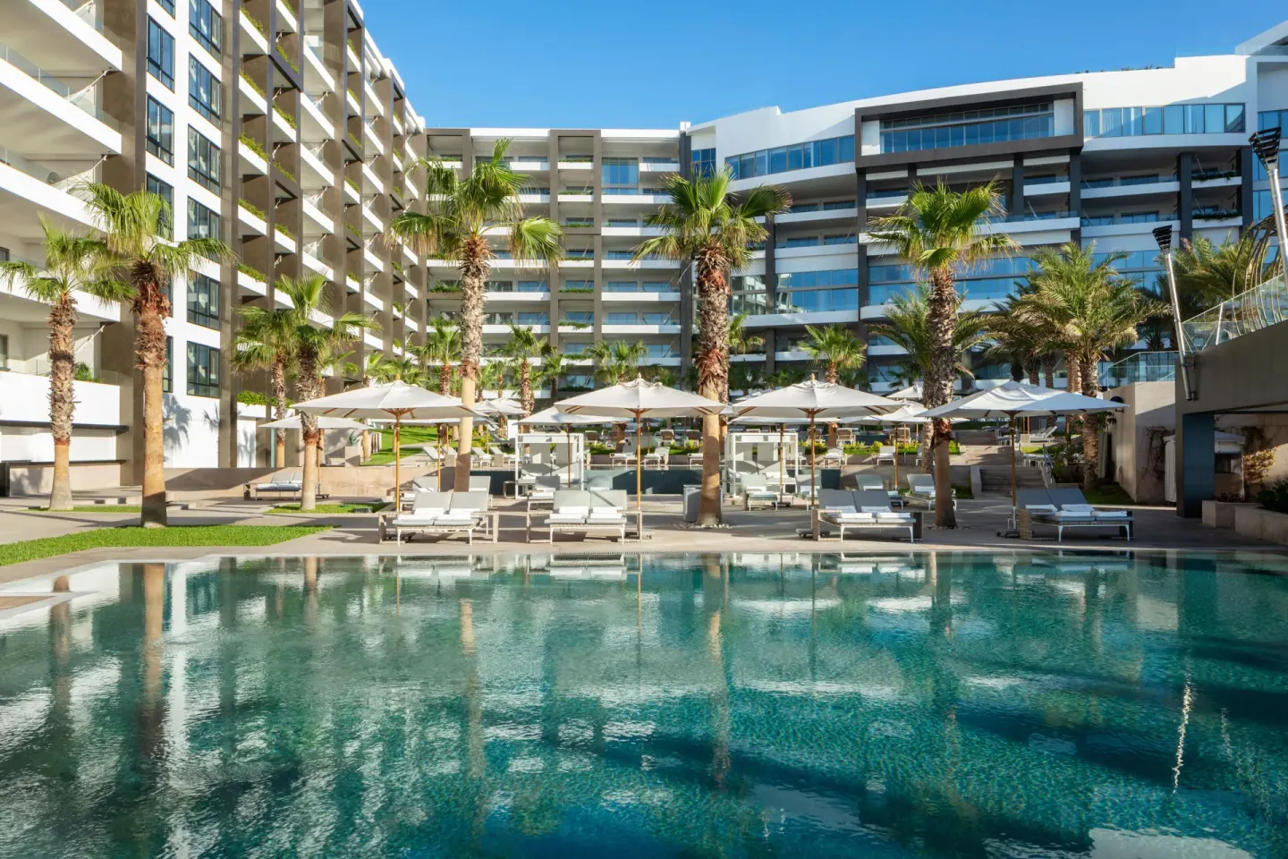 Main pool courtyard with palms and resort buildings at Garza Blanca Los Cabos.