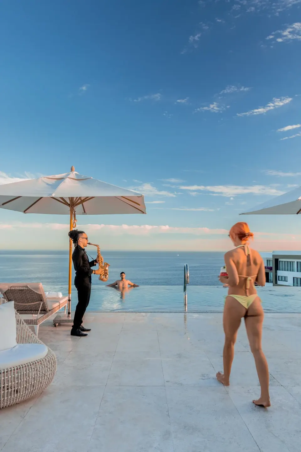 Rooftop infinity pool with a saxophonist and ocean view at Garza Blanca Los Cabos.