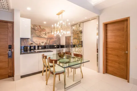 1 Bedroom Suite dining table and kitchenette with chandelier at Garza Blanca Los Cabos.