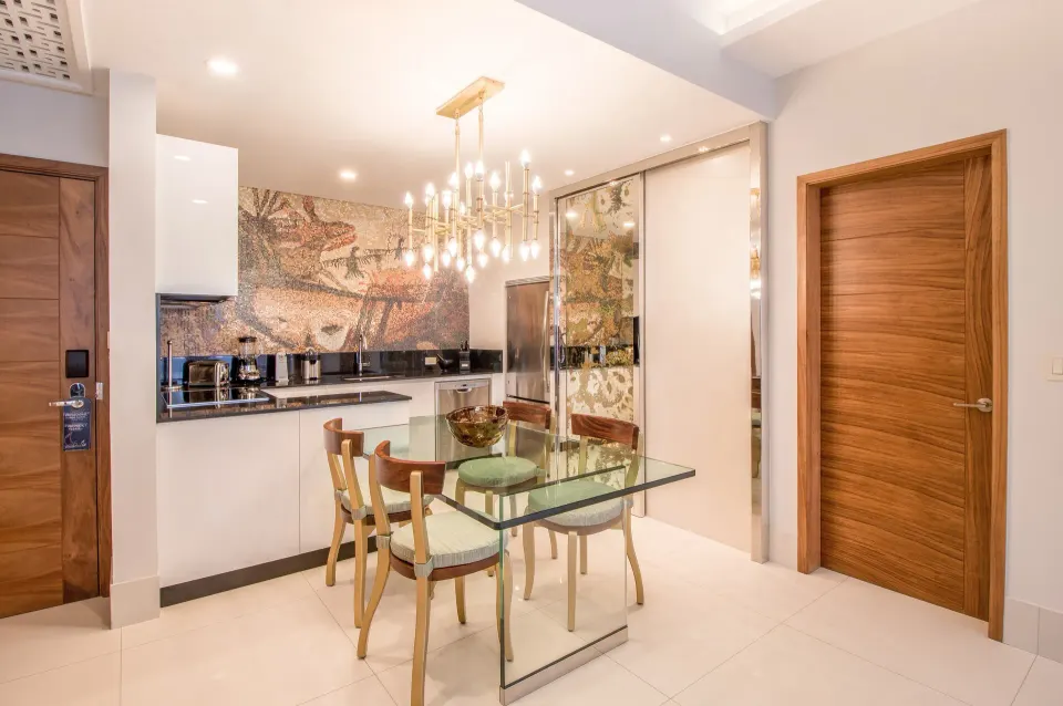 1 Bedroom Suite dining table and kitchenette with chandelier at Garza Blanca Los Cabos.