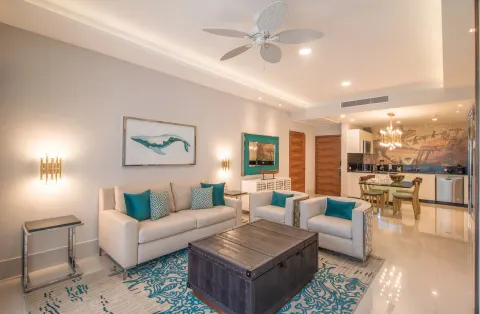 1 Bedroom Suite living room with sofa, chairs, dining area and kitchenette at Garza Blanca Los Cabos.