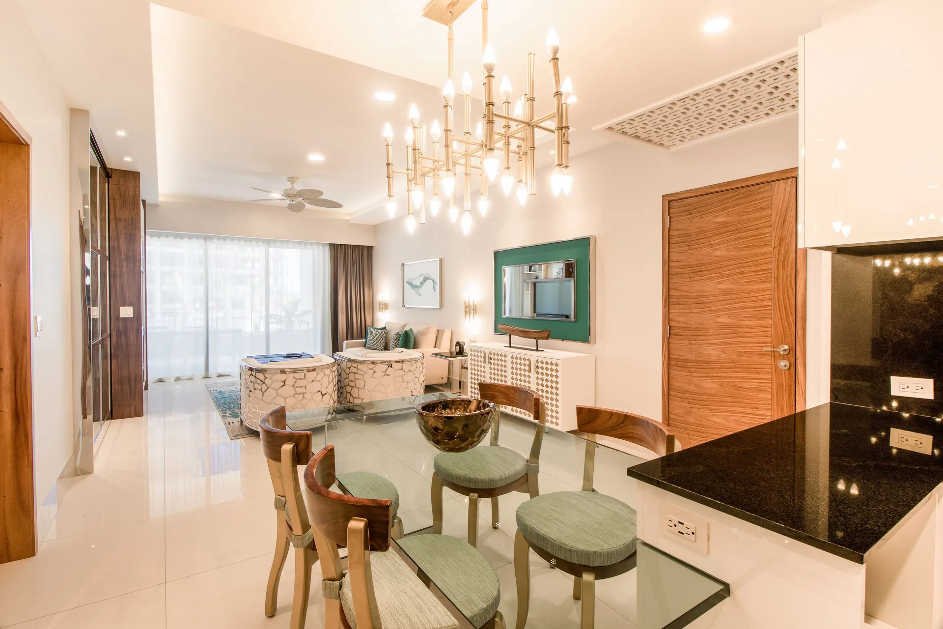Dining area of the 2 Bedroom Suite King at Garza Blanca Los Cabos with glass table and chandelier.