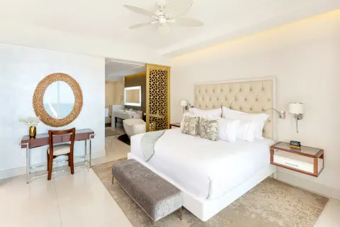 King bedroom with vanity and open bathroom in the suite at Garza Blanca Los Cabos.