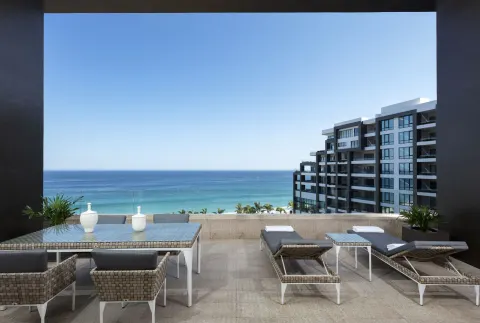 4 Bedroom Loft Ocean View terrace at Garza Blanca Los Cabos with dining set, loungers, and ocean view.