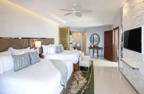 4 Bedroom Loft Ocean View two-bed bedroom at Garza Blanca Los Cabos with TV and open bath area.