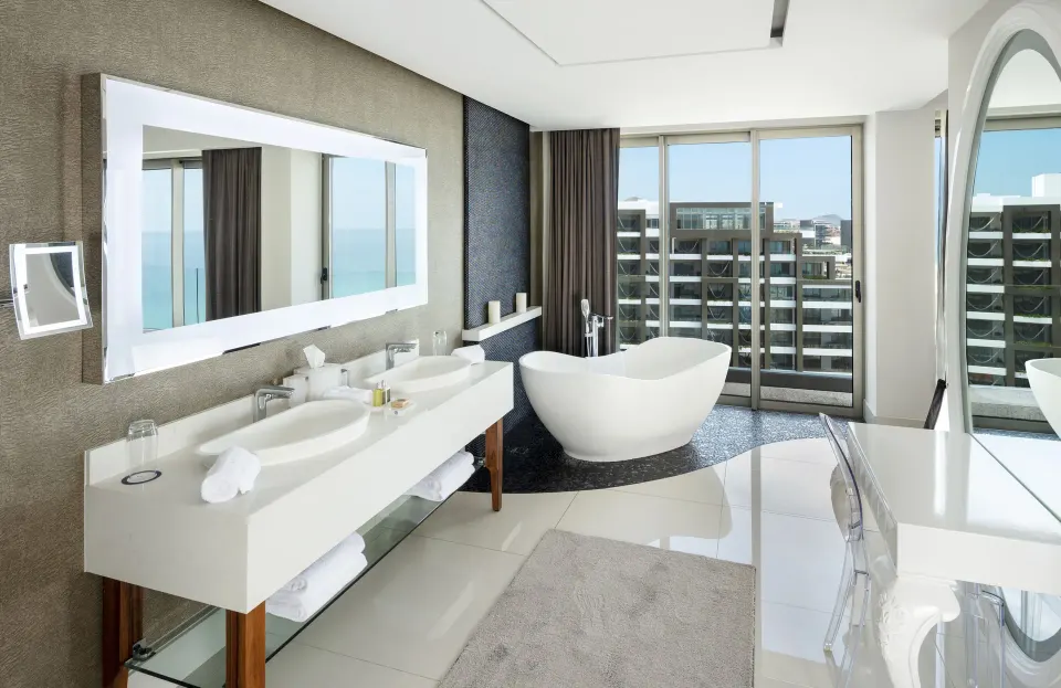 Penthouse bathroom at Garza Blanca Los Cabos with double vanity, soaking tub, and balcony windows.