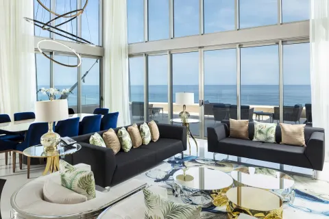 Penthouse living room with sofas and ocean-facing windows at Garza Blanca Los Cabos.