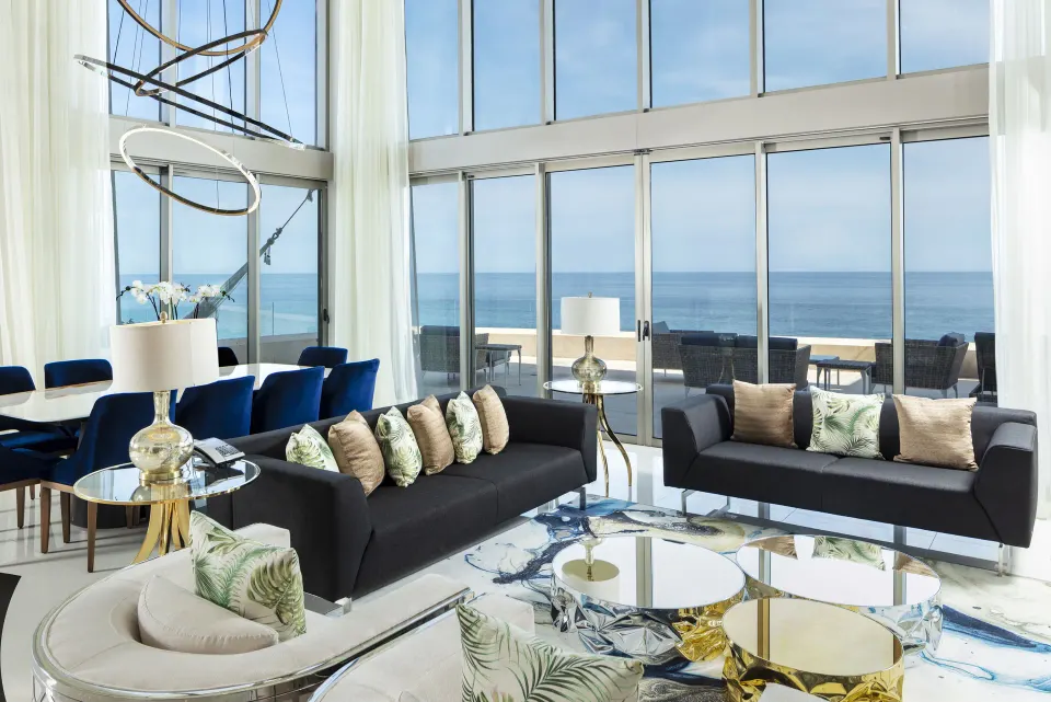 Penthouse living room with sofas and ocean-facing windows at Garza Blanca Los Cabos.