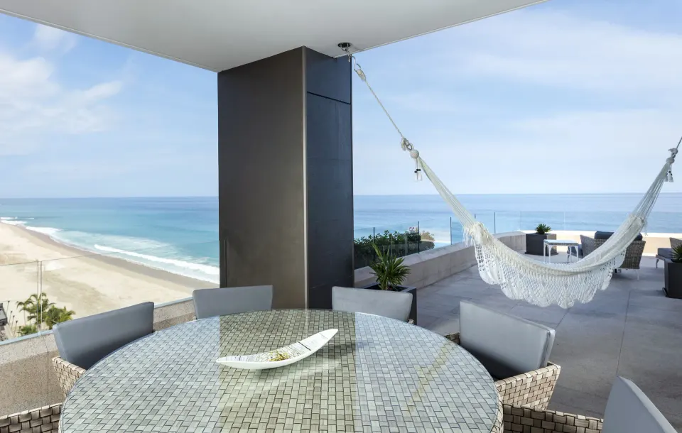 Penthouse oceanfront terrace with dining table and hammock at Garza Blanca Los Cabos.